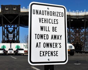 Unauthorized vehicles towed away sign