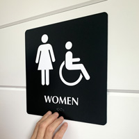 Braille women’s room sign with ADA symbol